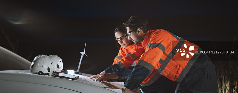 白人工程师情侣在风力发电场户外现场合作，夜间在车旁进行团队讨论。风力涡轮机可持续清洁能源，自然力量工程技术概念图片素材