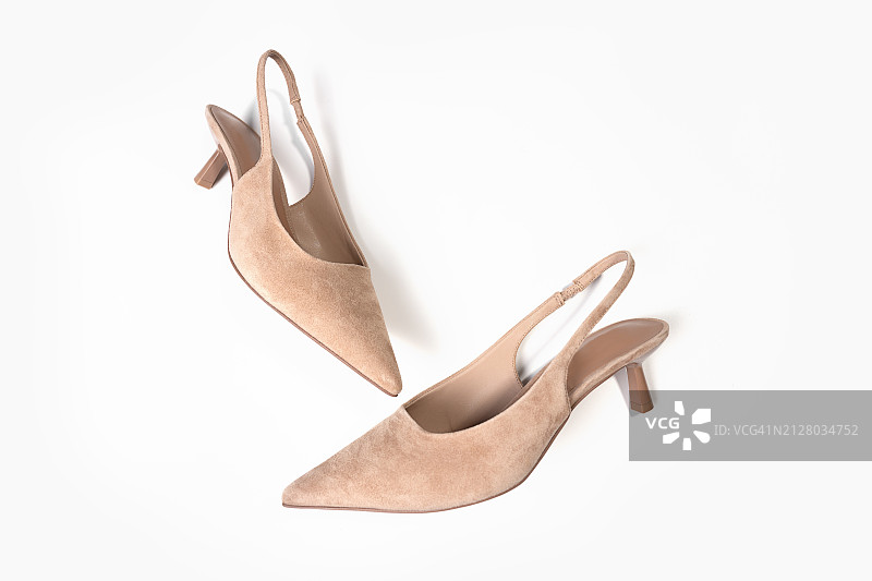 白色背景上的米色女士绒面革高跟鞋图片素材
