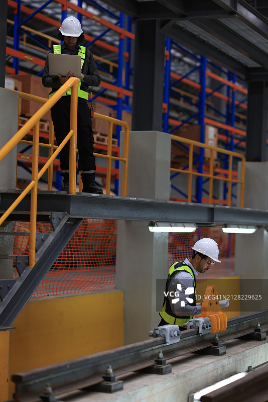 穿戴安全个人防护装备的机械或轨道系统工程师在火车库中进行质量检查图片素材