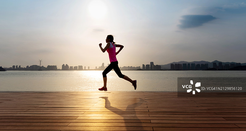 在海边栈道上奔跑的女人图片素材