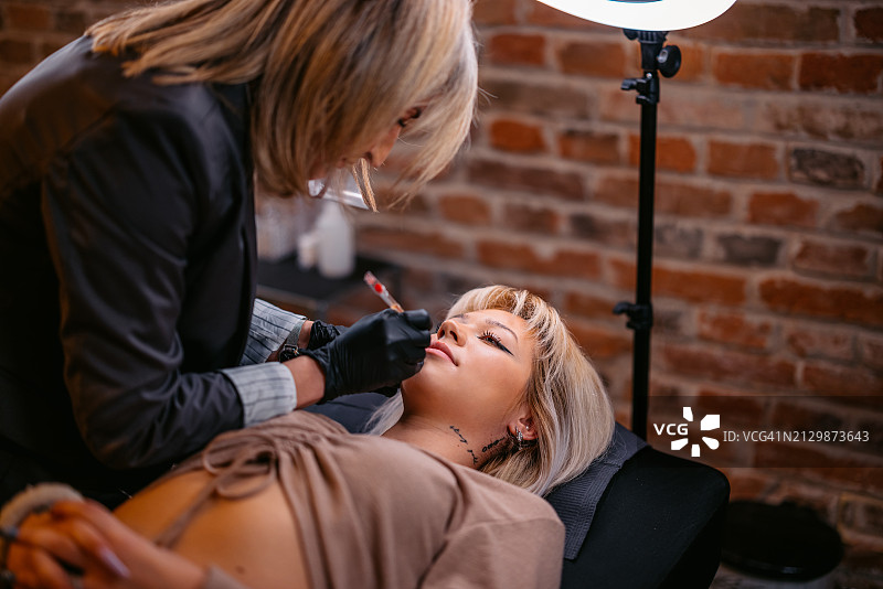 女美容师在美容院为顾客纹唇图片素材