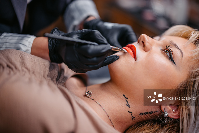 女美容师在美容院为顾客纹唇图片素材