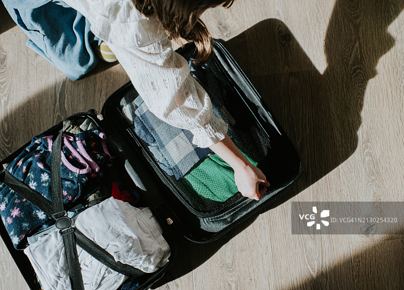儿童整理小行李箱的俯视照片图片素材