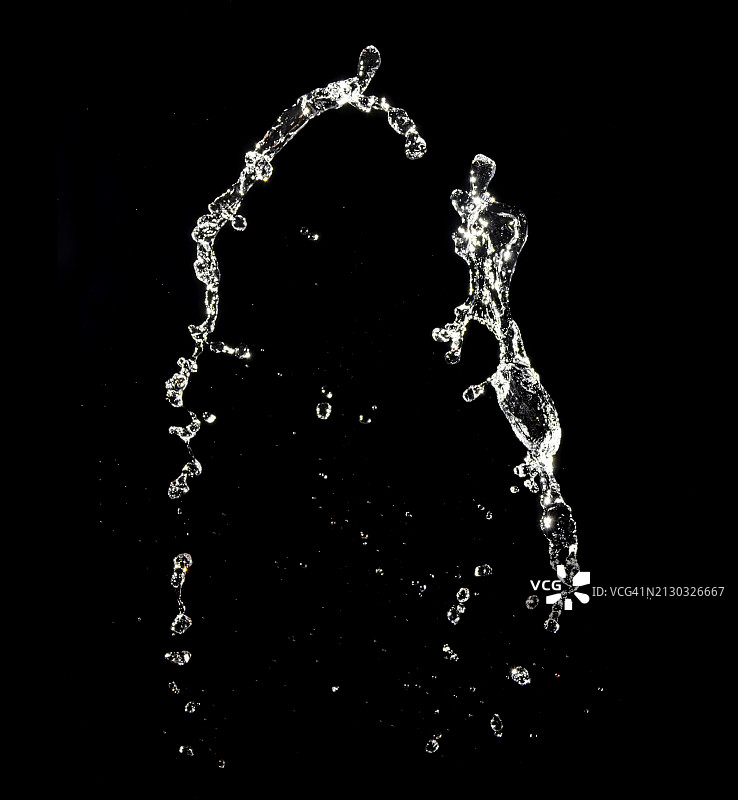 黑色背景上的水花飞溅和水滴运动图片素材