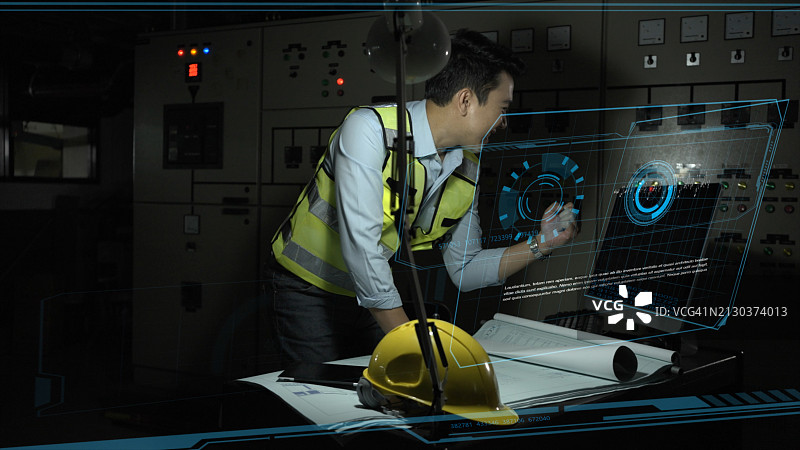 老年工程师在弱光条件下用电脑检查产品图片素材