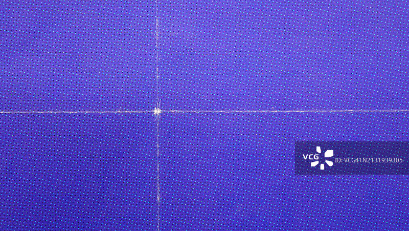 法国巴黎墙上粘贴的紫色折叠海报微距照片，胶印：浅蓝色、粉色和黑色点在紫色背景上，阳光，自然色调图片素材