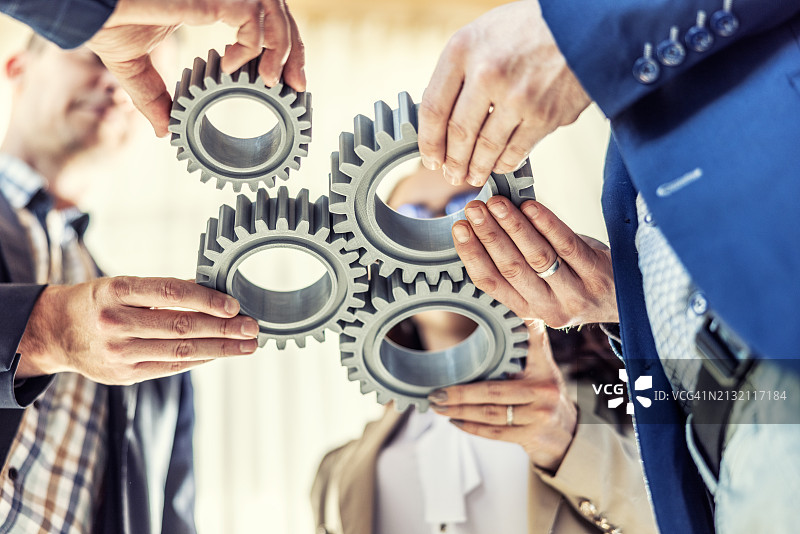 商业人士连接齿轮，象征合作与团队精神图片素材