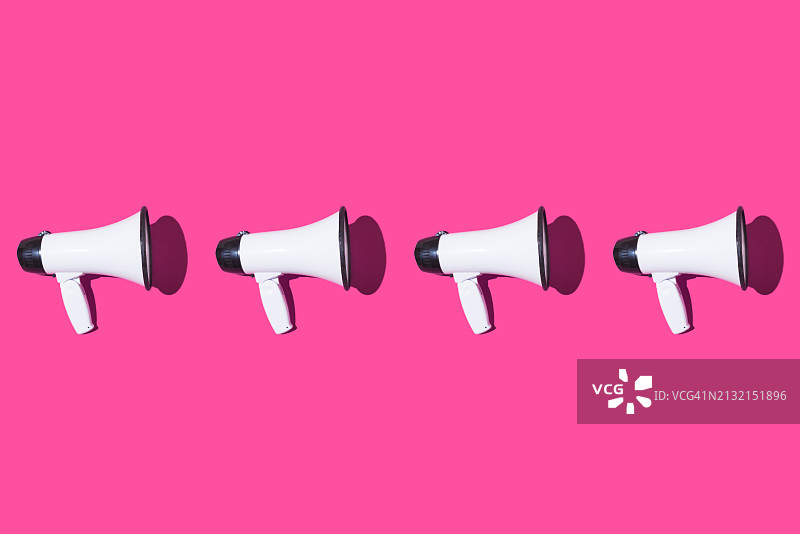 粉色背景上的一排白色扩音器图案图片素材