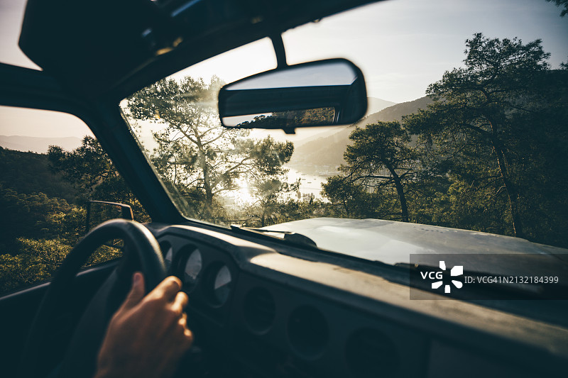 一个男人正沿着森林道路开车图片素材