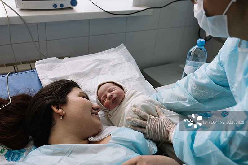 分娩后，母亲第一次见到新生婴儿。图片素材