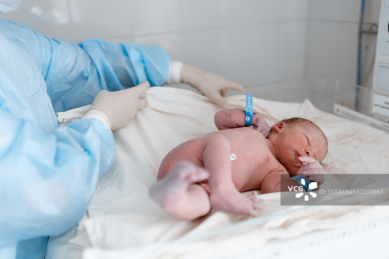 医护人员用白色亚麻布包裹新生婴儿图片素材