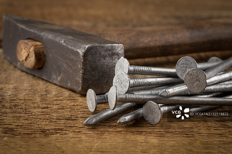 木质背景上的复古铁锤和钉子图片素材