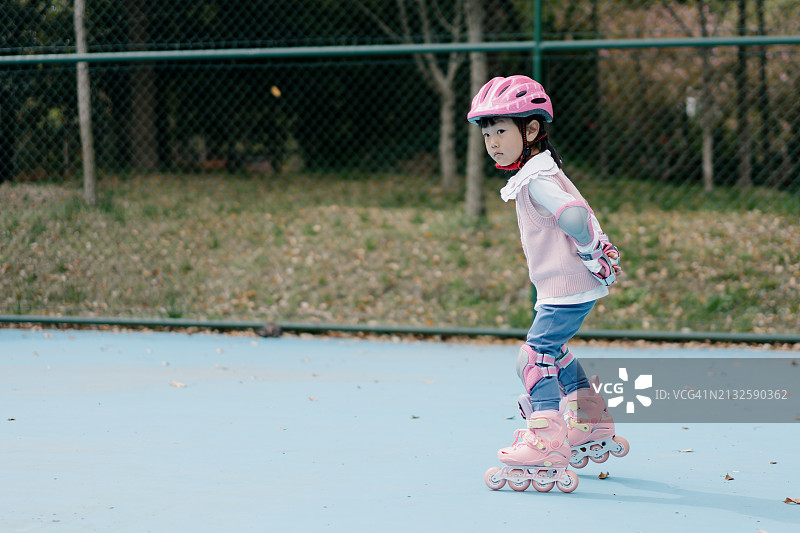 在城市公园里玩滑板的亚洲小女孩图片素材