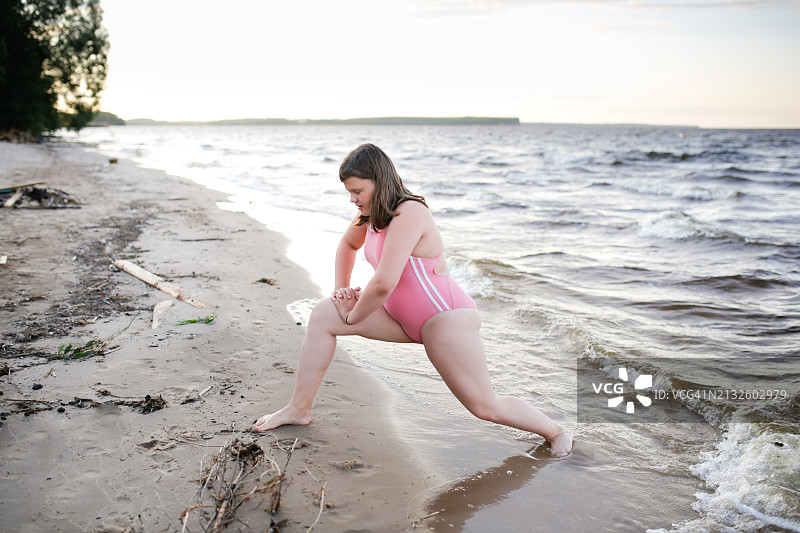 在湖边穿着泳衣锻炼的胖乎乎的少女图片素材