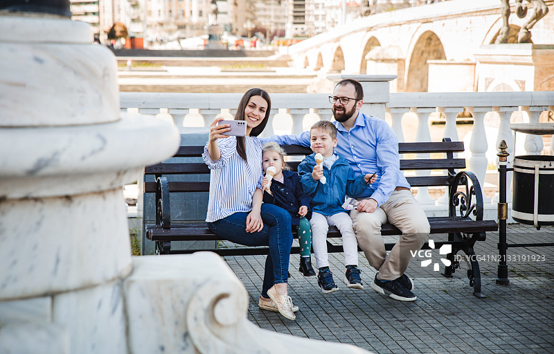 一家人在城市长椅上放松图片素材