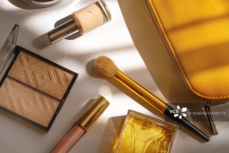 俯视角度的化妆包和化妆品，橙色化妆包和女士化妆品在白色背景上图片素材