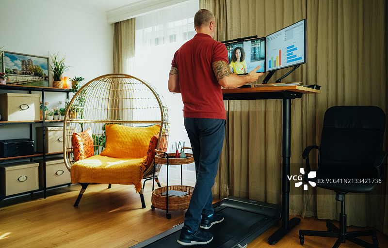 商务人士在跑步机上与同事进行视频通话图片素材
