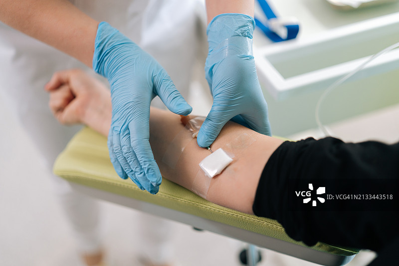 熟练的护士为诊所的女病人进行静脉输液（高角度）图片素材