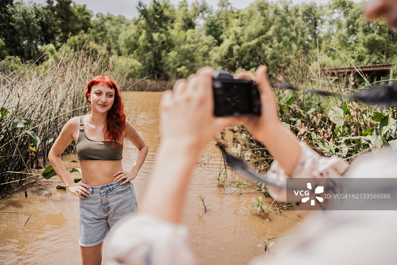 年轻女人在河边拍照摆姿势图片素材