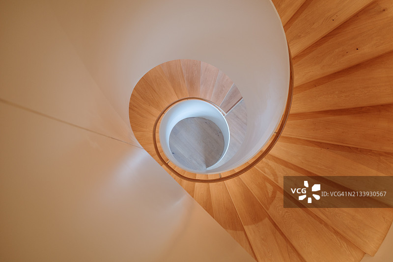 现代螺旋楼梯：白色栏杆与暖色木质台阶图片素材