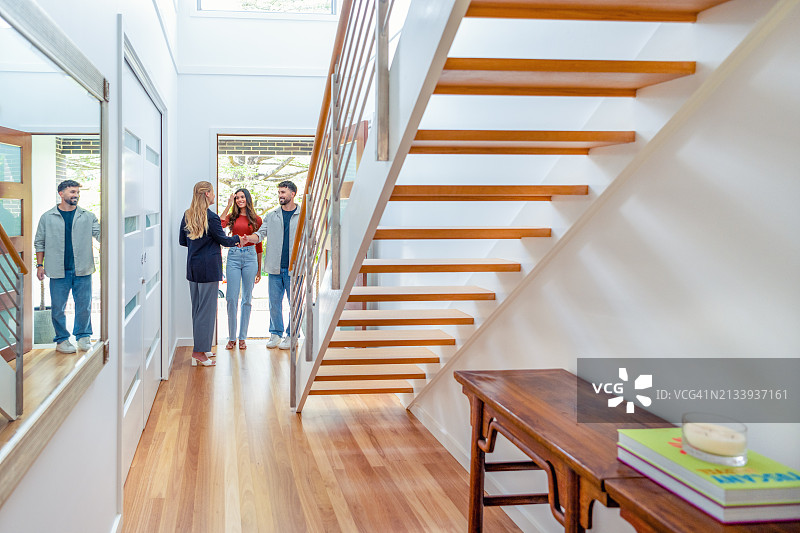 房产中介向一对年轻夫妇展示新房图片素材