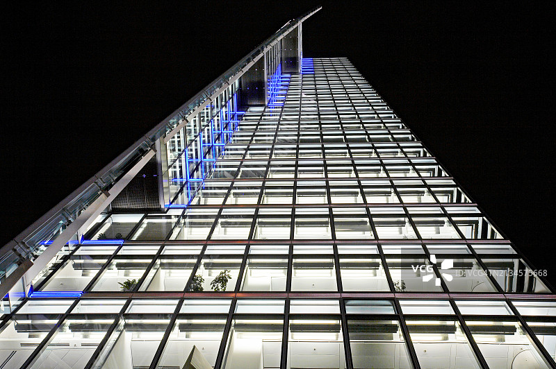 夜晚办公摩天大楼的现代玻璃幕墙图片素材