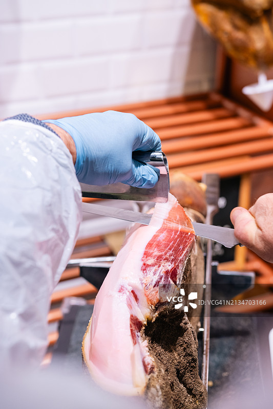 切割伊比利亚火腿的手部特写图片素材