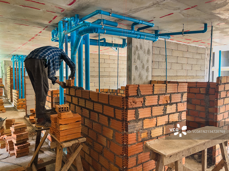 工人们合力将砖块砌成建筑物的形状图片素材