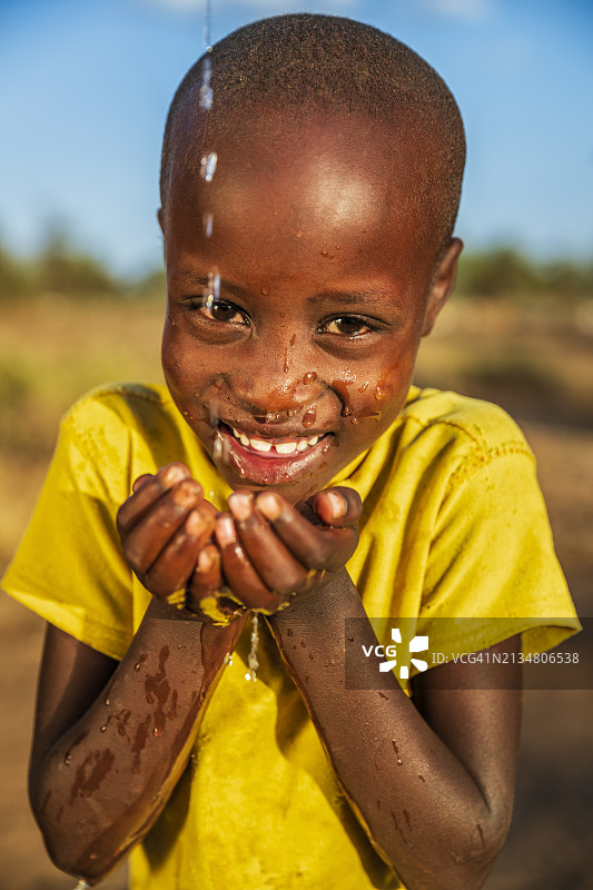 非洲年轻女孩在东非草原上喝水图片素材