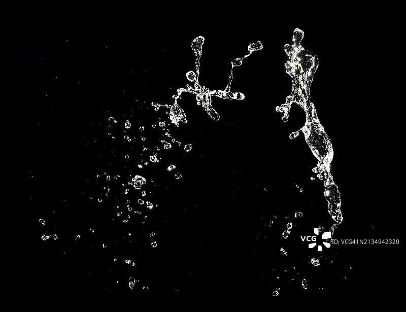 黑色背景上，自然水花飞溅和水滴运动图片素材