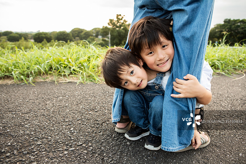 孩子们蹲在父母的腿下图片素材