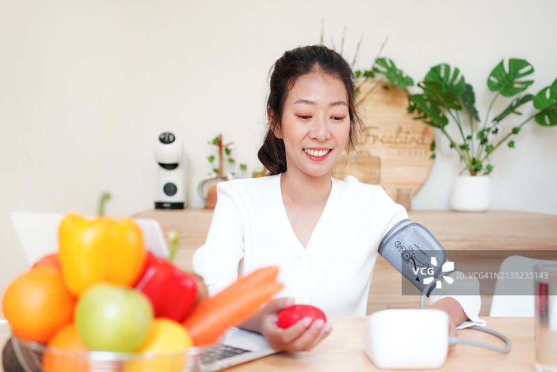 女病人在家使用血压测量仪检查血压和心率图片素材