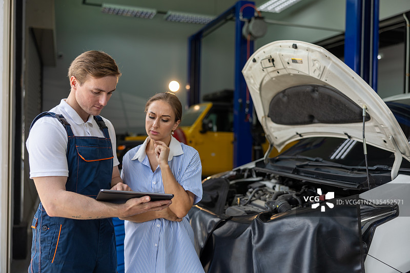 汽车维修工向女顾客讲解汽车维修保养图片素材