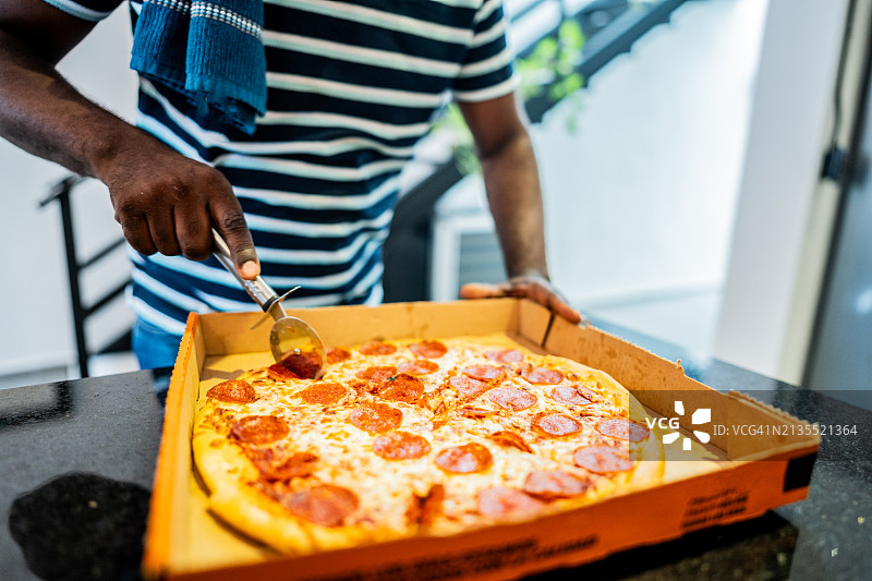男子切披萨的特写图片素材