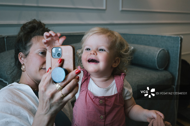母亲和幼儿玩手机图片素材