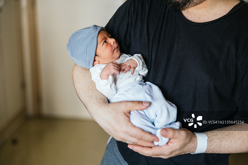 新生婴儿在父亲和他说话时专心看着他图片素材