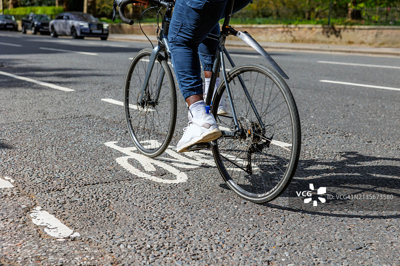 在自行车道上骑自行车的男子腿部特写图片素材