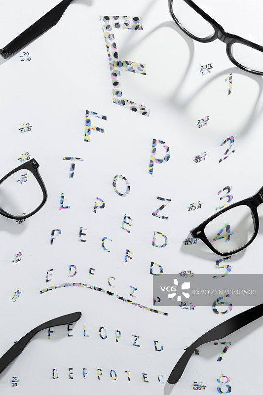 白色背景上带有视力表文字的眼镜的俯视图，美国迈阿密，佛罗里达州图片素材