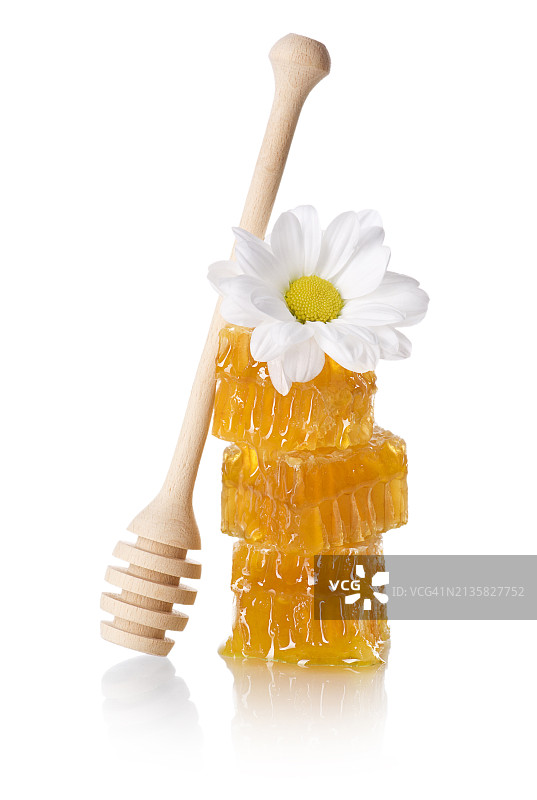 白色背景下的花朵和蜂蜜勺子特写图片素材