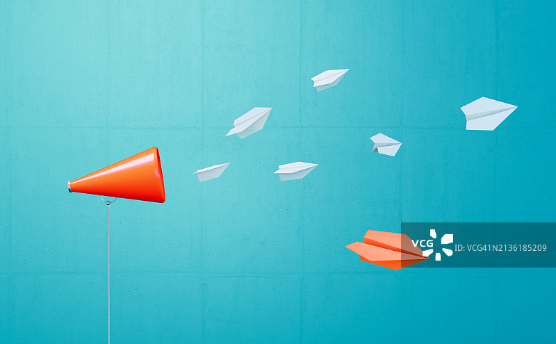 蓝色背景前，白色纸飞机从珊瑚色扩音器飞走图片素材