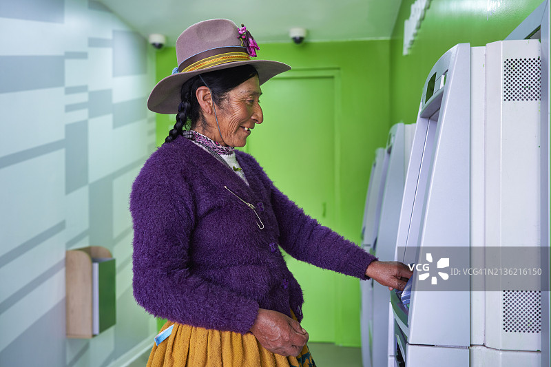 秘鲁的克丘亚族妇女身穿传统服装在ATM机上输入密码取款图片素材