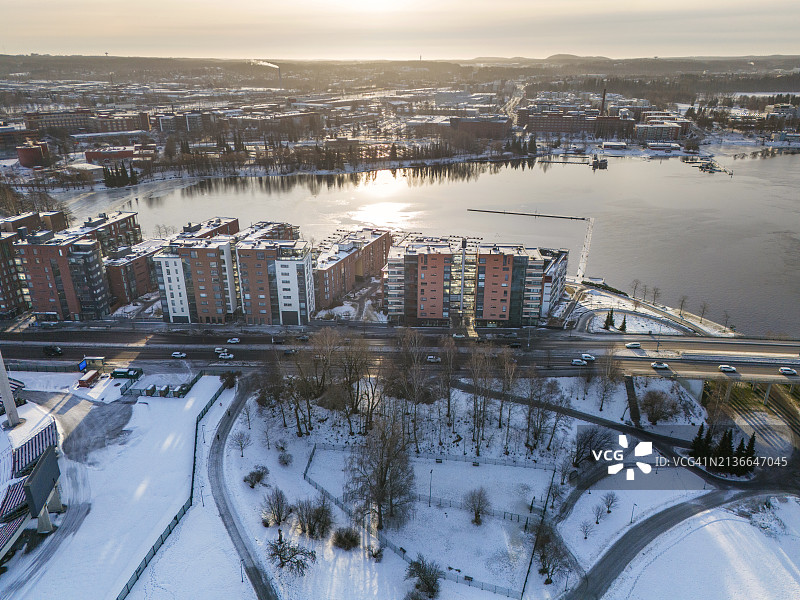 被白雪覆盖的公园和阳光下的公寓楼图片素材