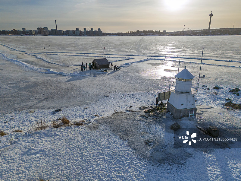 冬季阳光下的冰冻湖面和Siilinkari灯塔图片素材