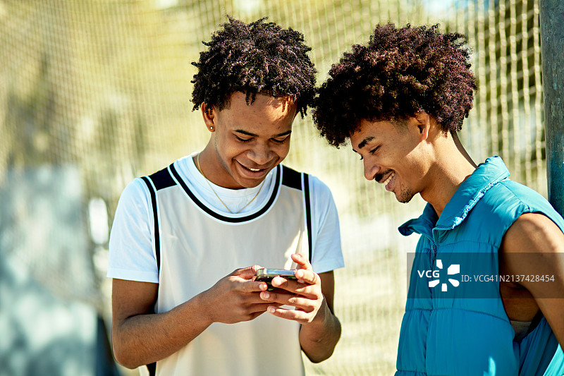 看着社交媒体并微笑的年轻男人图片素材