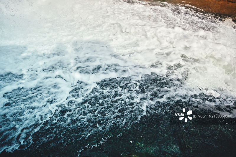 湍流水的特写。高速捕获的泡沫海浪的动态纹理。图片素材