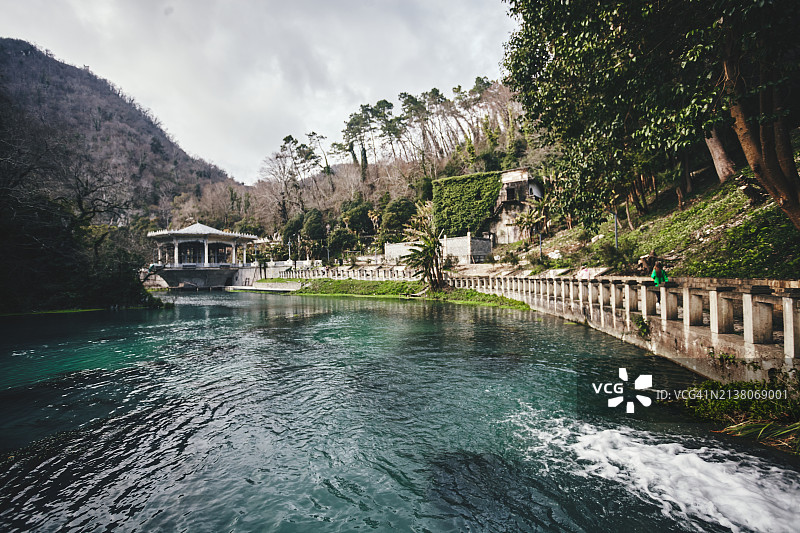 阴天绿树环绕的湖边废弃火车站亭图片素材