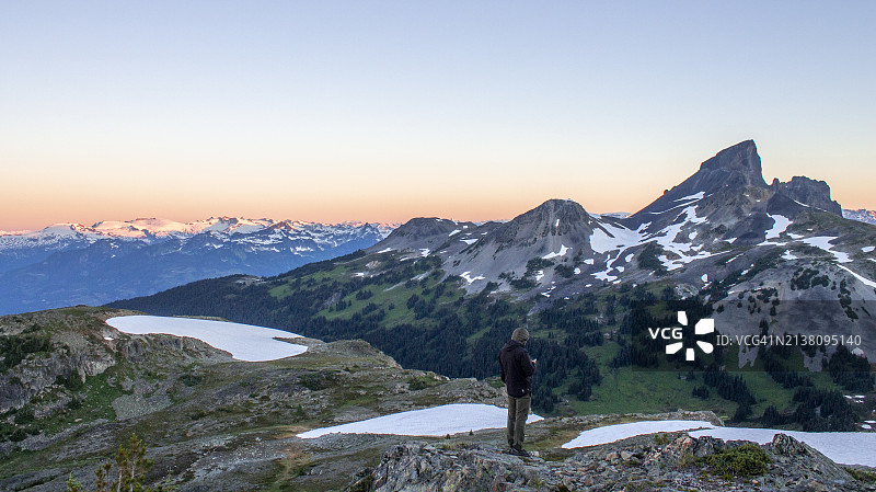 背包客在黎明时分在山脊上休息图片素材