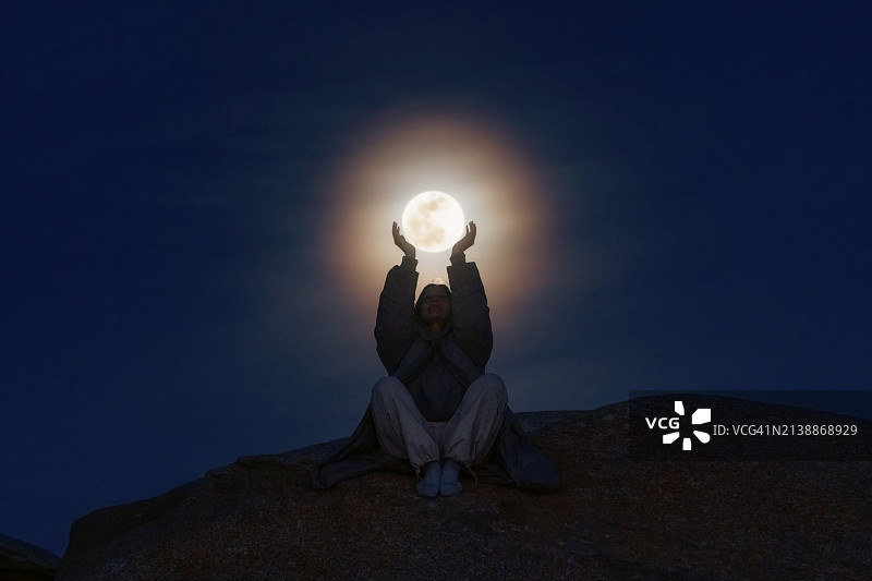 年轻女子用双手捧着满月图片素材