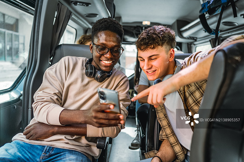 朋友们在公交车上一起看手机图片素材