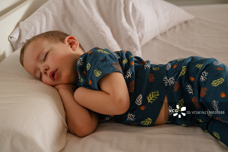 早上在床上睡觉的可爱4岁男孩图片素材